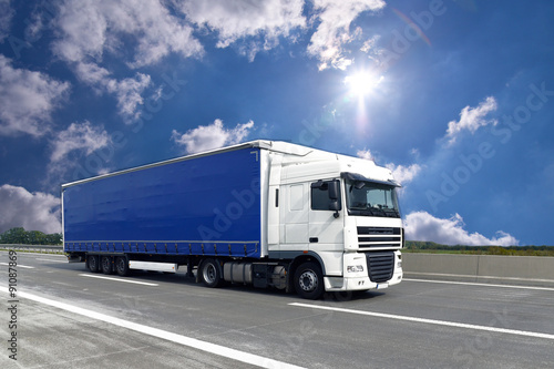 fahrender LKW auf einer Autobahn transportiert Güter // truck on highway - shipping and logistics