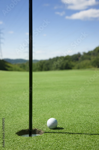 Golf ball at the edge of the hole.