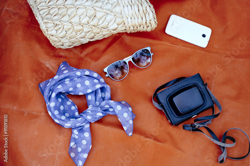 Female accessories: bag, scarf, sunglases, smartphone and camera photo