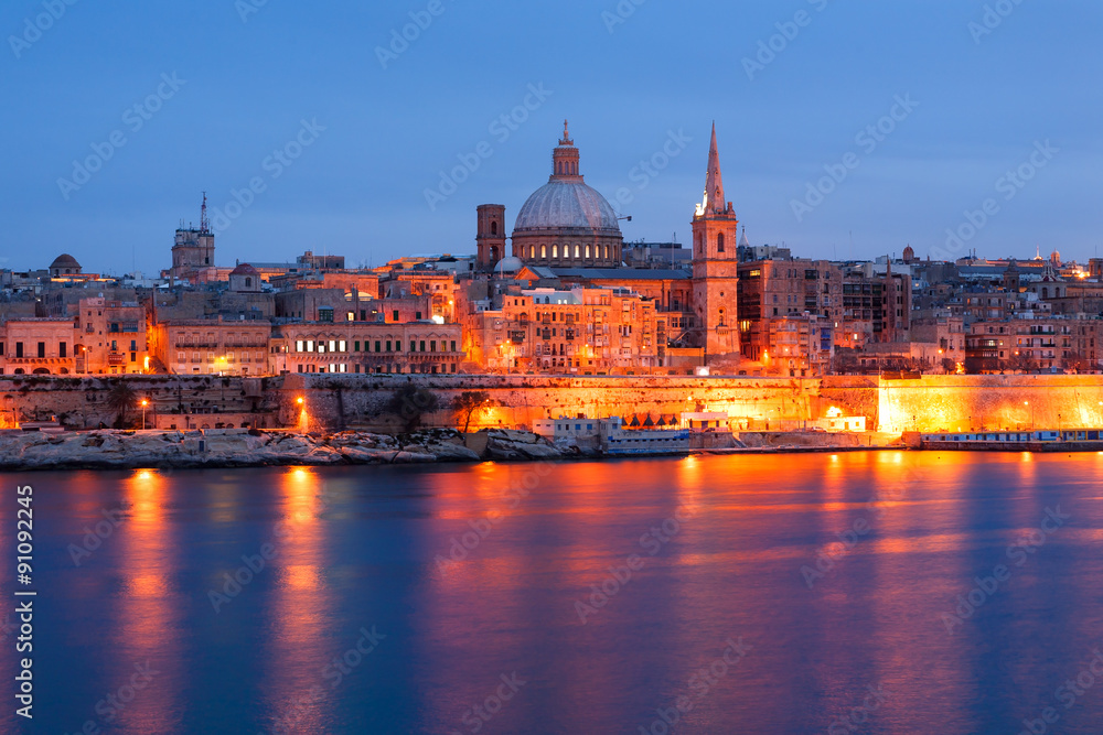 Valletta seafront skyline view as seen from Sliema, Malta. Illuminated historical buildings after sunset.