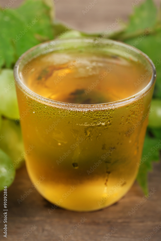 Glass of cool grape juice on wooden table, closeup Glass of cool grape juice on wooden table, closeup