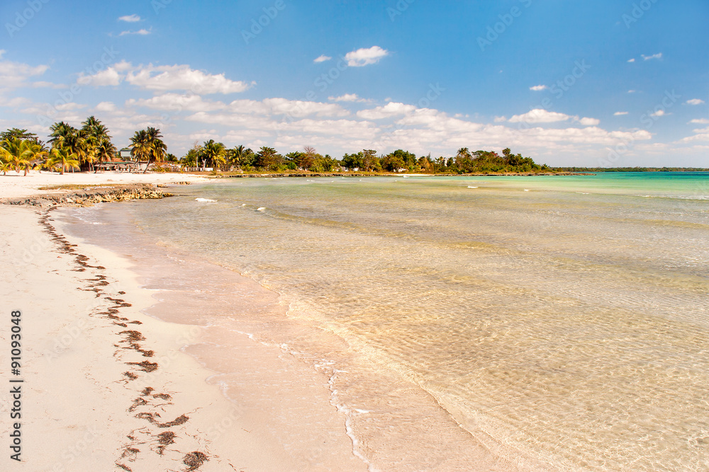 Сoast of one of the islands of Cuba - sea waves, white sand and palm trees. Сoast of one of the islands of Cuba - sea waves, white sand and palm trees.