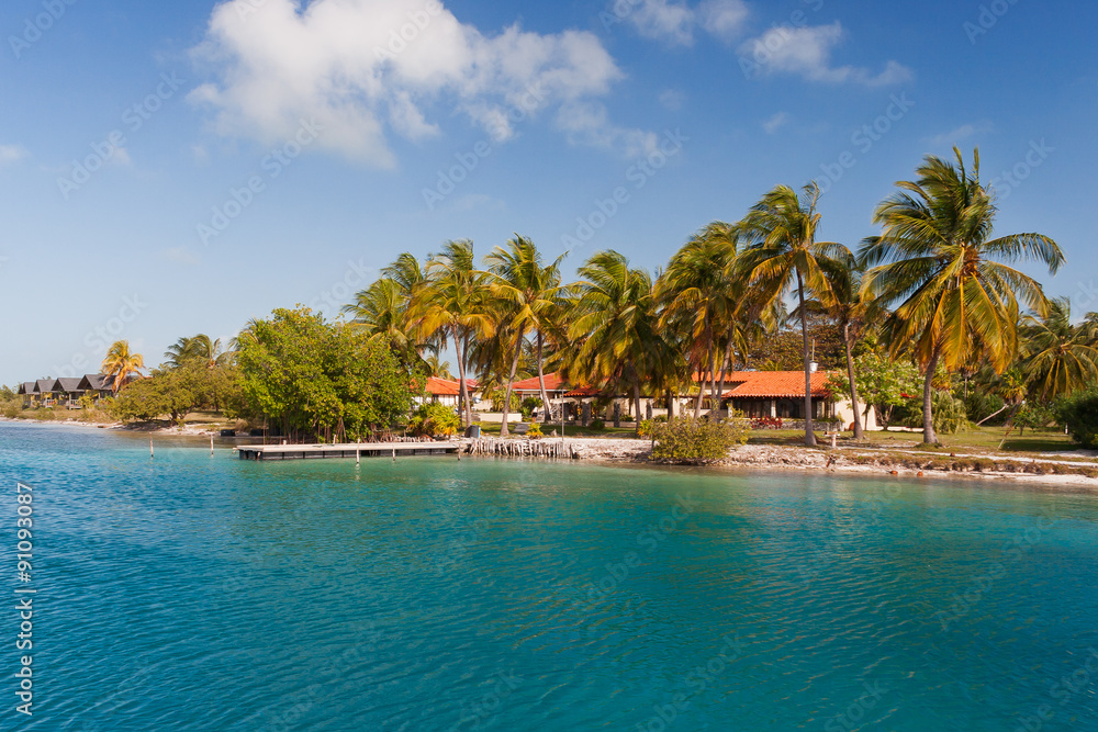 Coast of one of the islands of Cuba - sea, palms and bungalow.