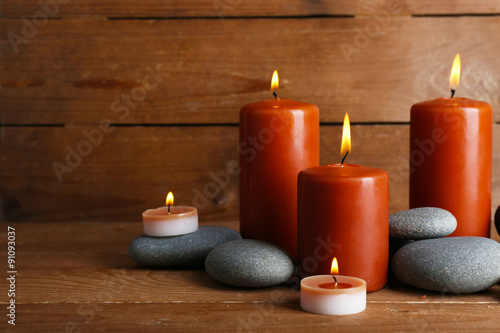 Beautiful spa stones with candles on wooden background