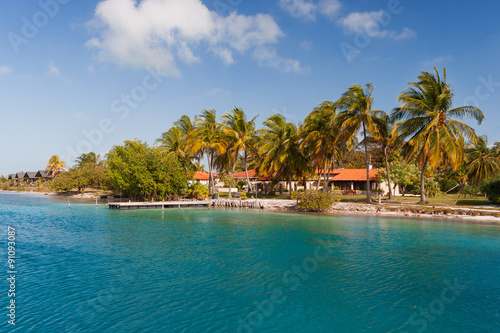 Coast of one of the islands of Cuba - sea, palms and bungalow.