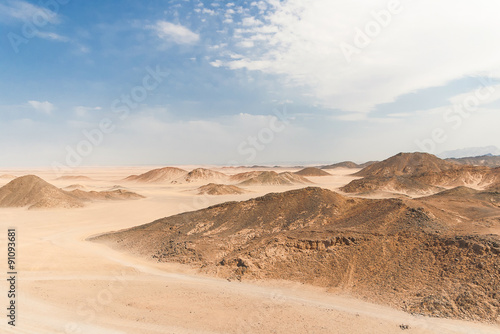 Beautiful desert landscape of Egypt. Yellow sand, mountains, clouds and blue sky.