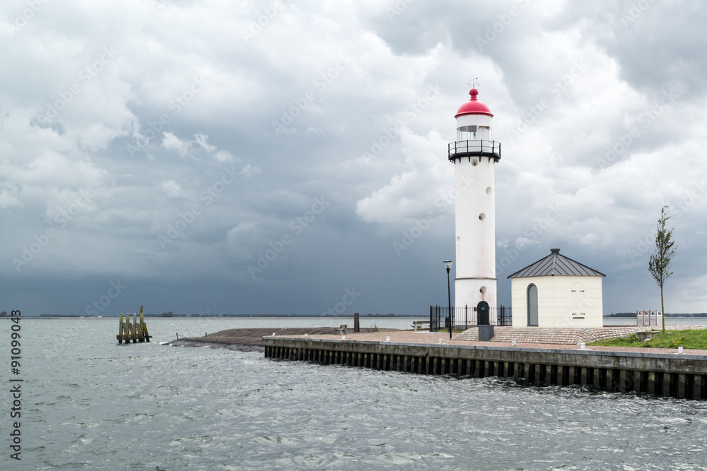 Lighthouse against dark sky of storm clouds in Hellevoetsluis, South Holland, Netherlands