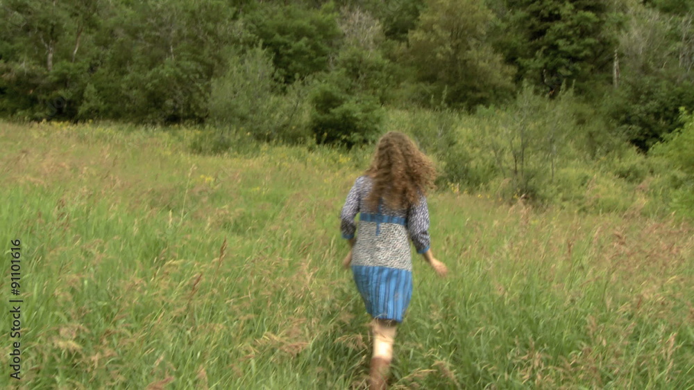 woman walking through a field with her dog woman walking through a field with her dog