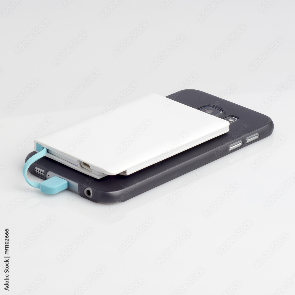 Charging a smartphone with powerbank on white Charging a smartphone with powerbank on white