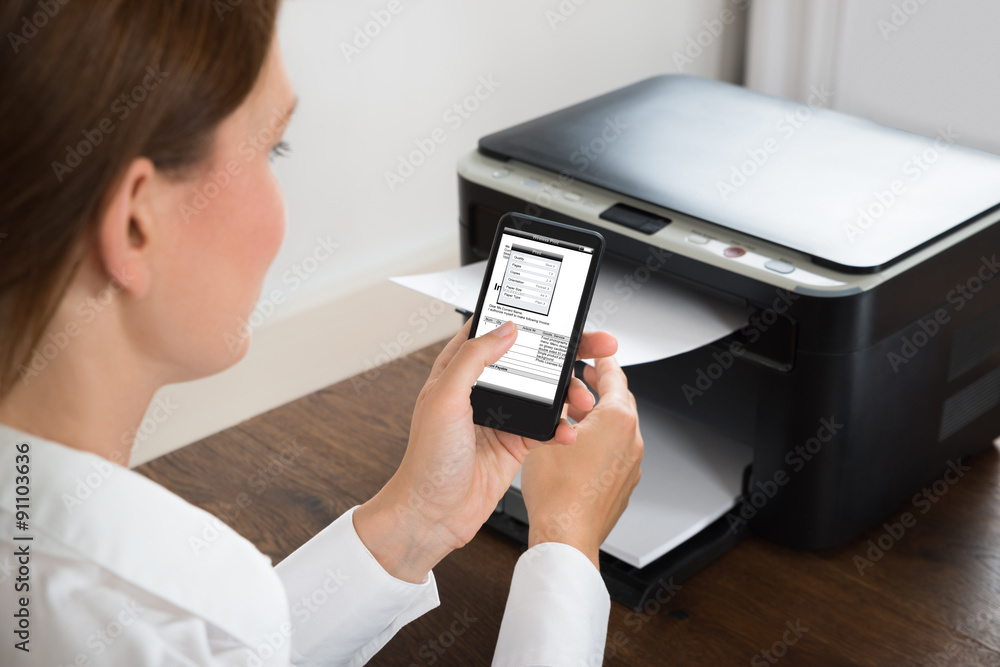 Businesswoman With Mobile Phone Connected To Printer Businesswoman With Mobile Phone Connected To Printer