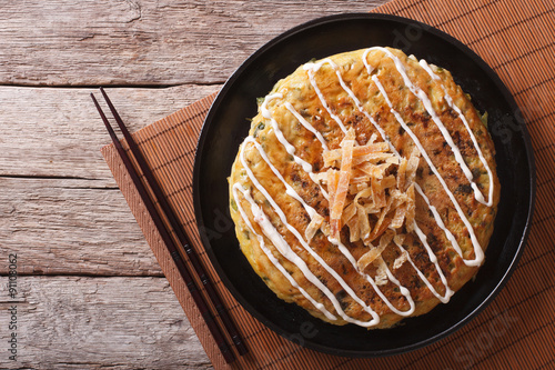 Japanese okonomiyaki on a wooden table. Horizontal top view
 photo