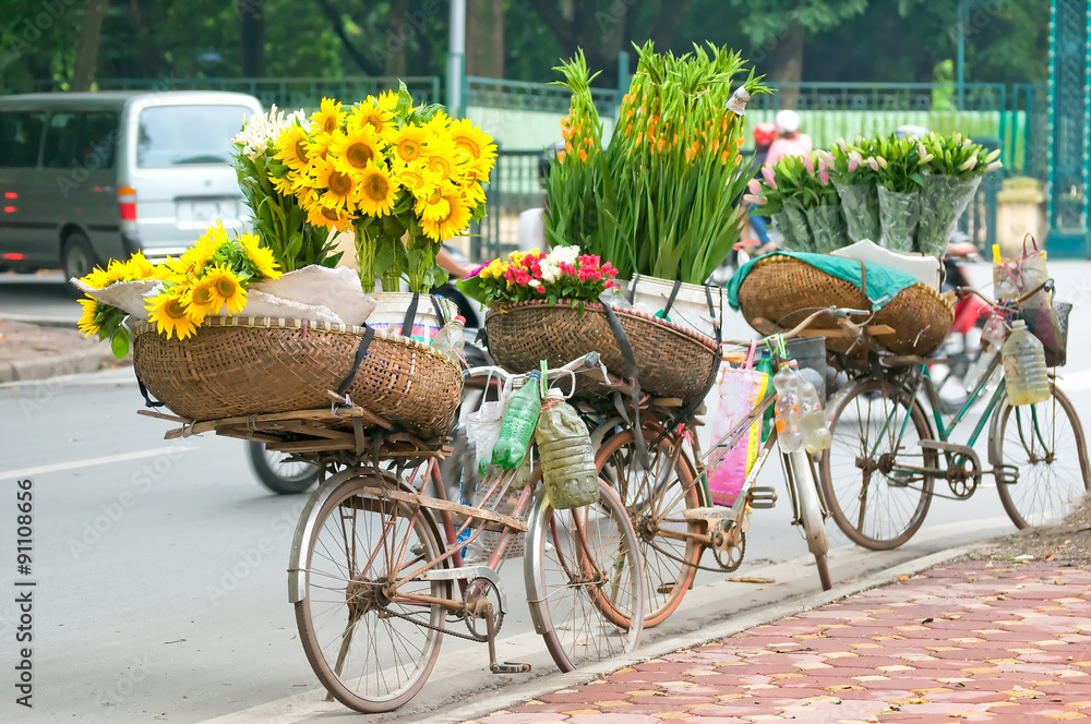 Selling flowers not red identity on the street in the early morning. Farmers use bicycle, on wearing the conical hat then go to the small lane to the florist.