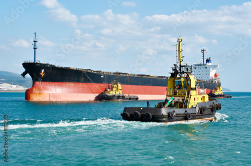 Tanker barge pushed powerful tugboats in sea