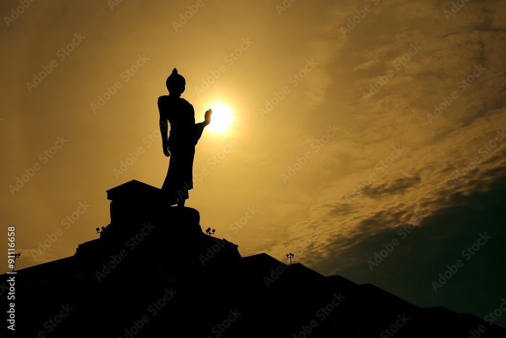 Thai buddha statue over scenic sunset sky background