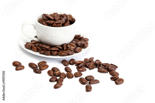 Coffee beans and ceramic cup on white background.