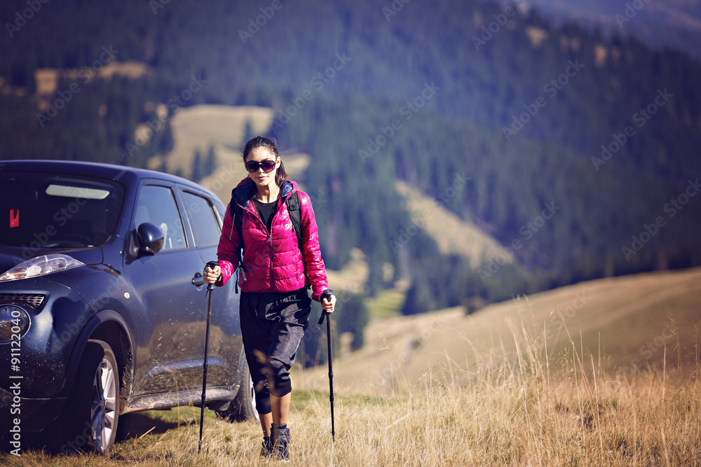 Woman Traveler with Backpack hiking in Mountains with beautiful