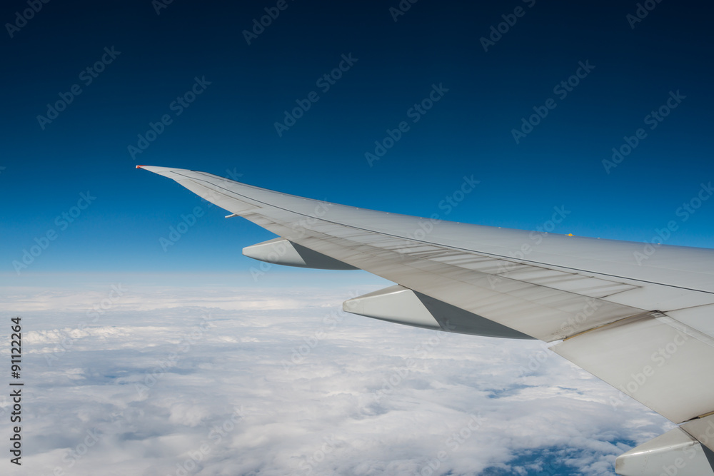 Wing of an airplane flying above the clouds. Wing of an airplane flying above the clouds.