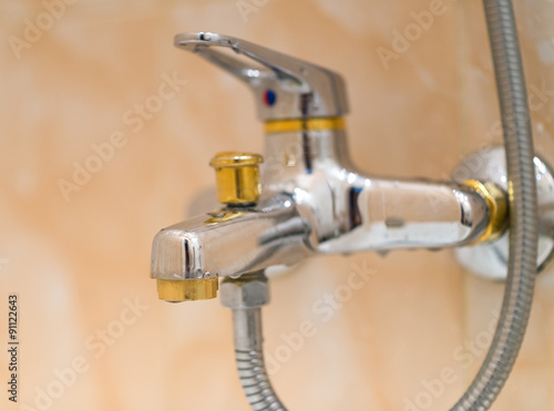 Closeup of faucet in modern bathroom. Selective focus with shallow depth of field.