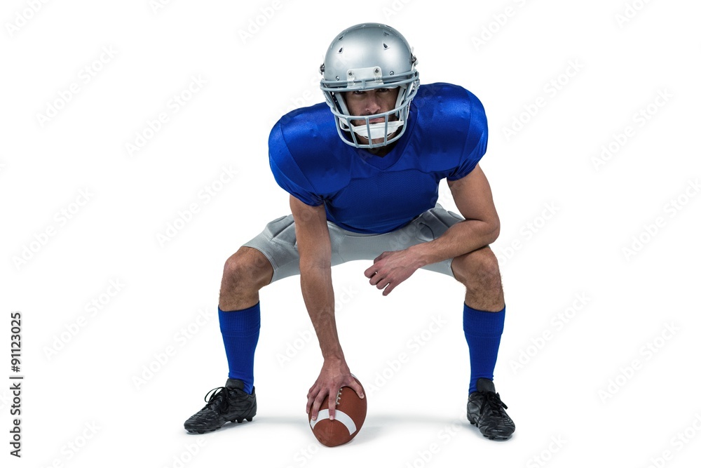 Full length of American football player placing ball Full length of American football player placing ball