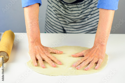Man hands making dough for dumplings with meat