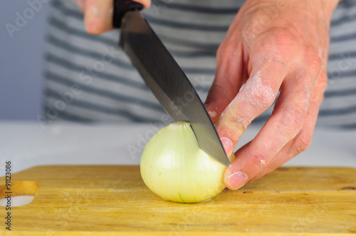 Man hands cutting onion