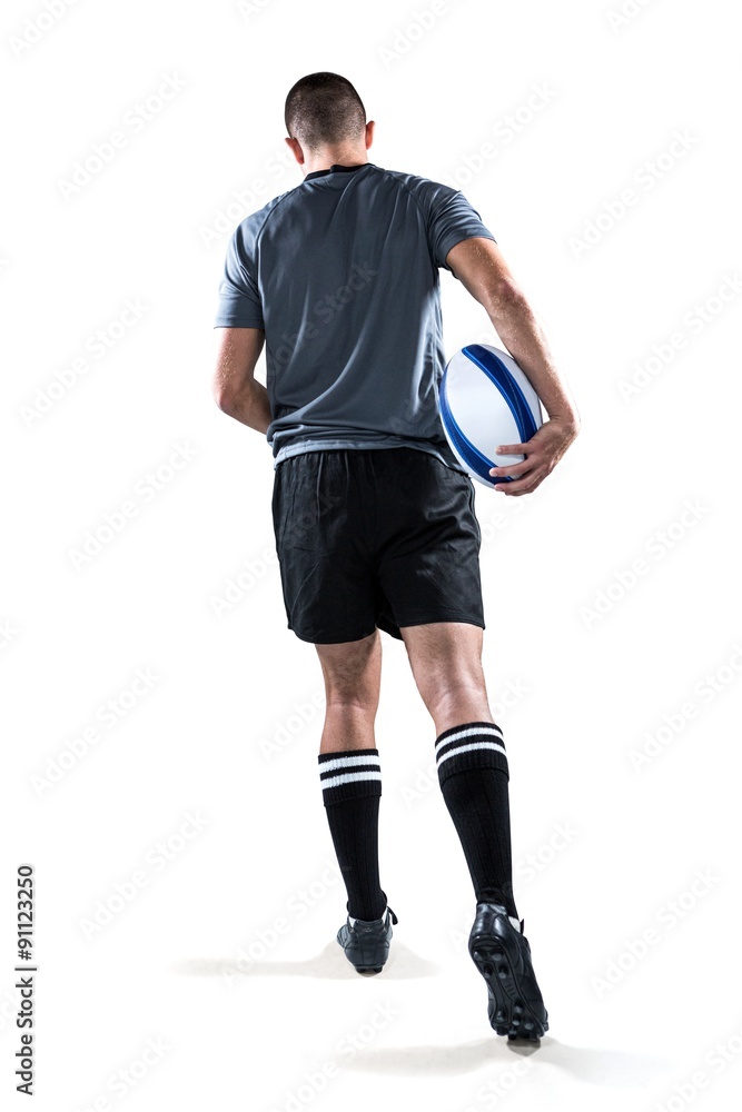 Rear view of rugby player running with ball