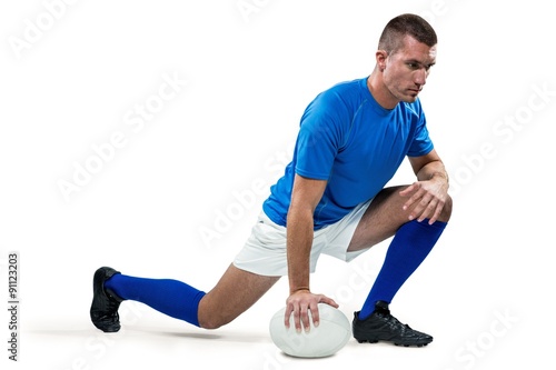 Rugby player stretching with ball