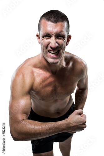 Excited shirtless athlete flexing muscles