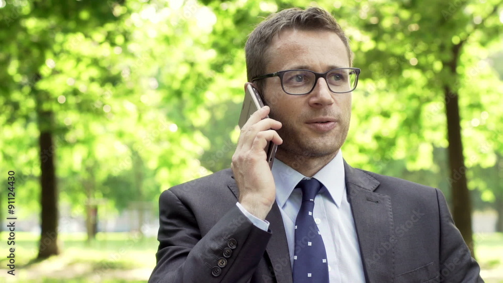 Businessman having a conversation on cellphone in the park
Businessman having a conversation on cellphone in the park