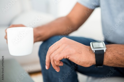 Close-up of man on coffee break with smart watch