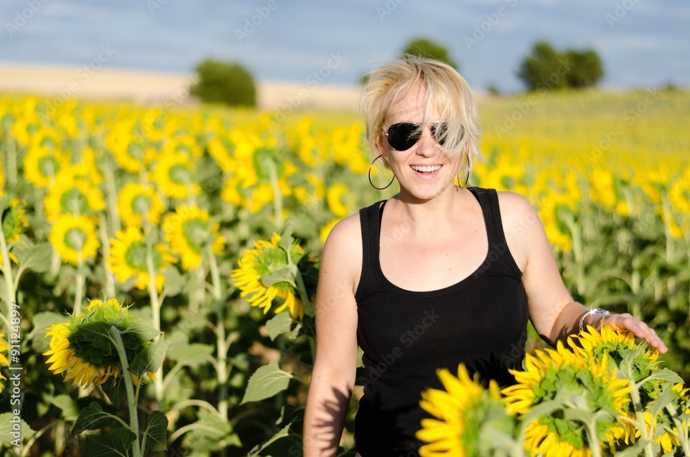 Beautiful lady walking in summer sunflower field Beautiful lady walking in summer sunflower field