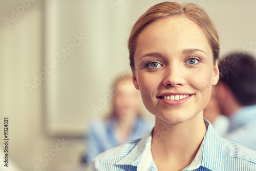 group of smiling businesspeople meeting in office