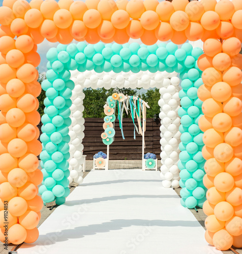 Balloon and paper arches like decorations for wedding ceremony in orange and blue colors