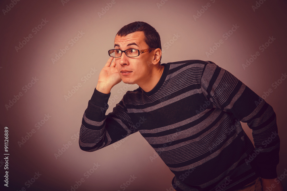 male of European appearance brunet put his hand to his ear eaves male of European appearance brunet put his hand to his ear eaves