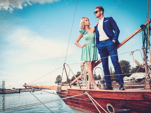 Stylish wealthy couple on a luxury yacht
