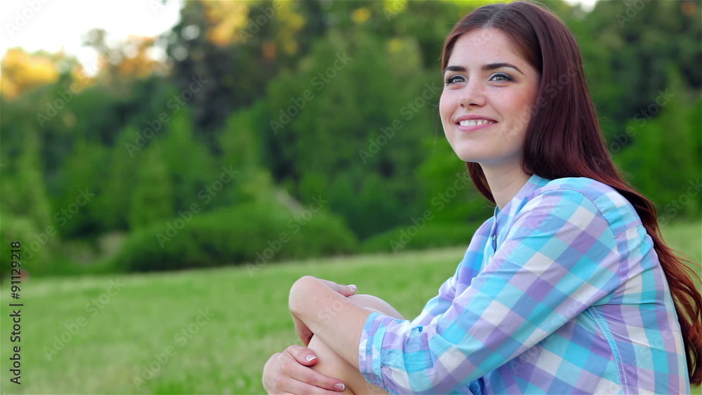 Beautiful girl relaxing in a field, drinking water Beautiful girl relaxing in a field, drinking water