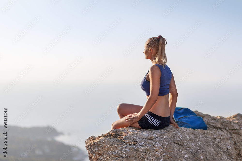 Woman with little bag on the rock