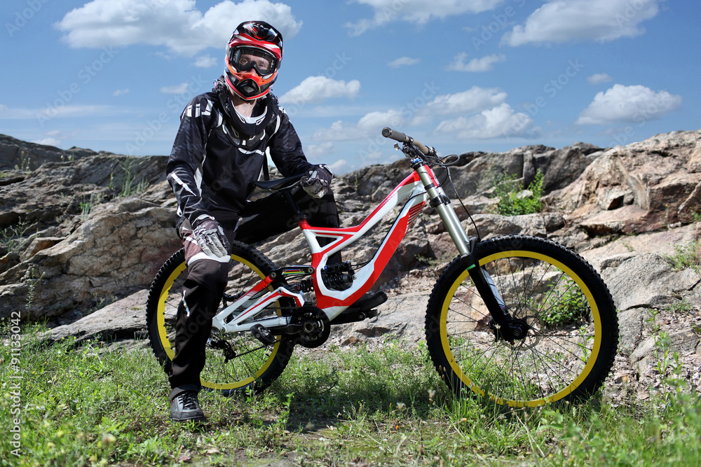 Sportsman in sportswear on a mountain bike rides on the stones in the  extreme style of downhill Stock Photo | Adobe Stock