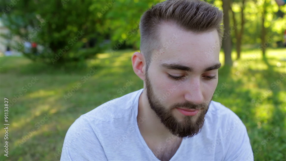Casual young man using a phone in the park Casual young man using a phone in the park