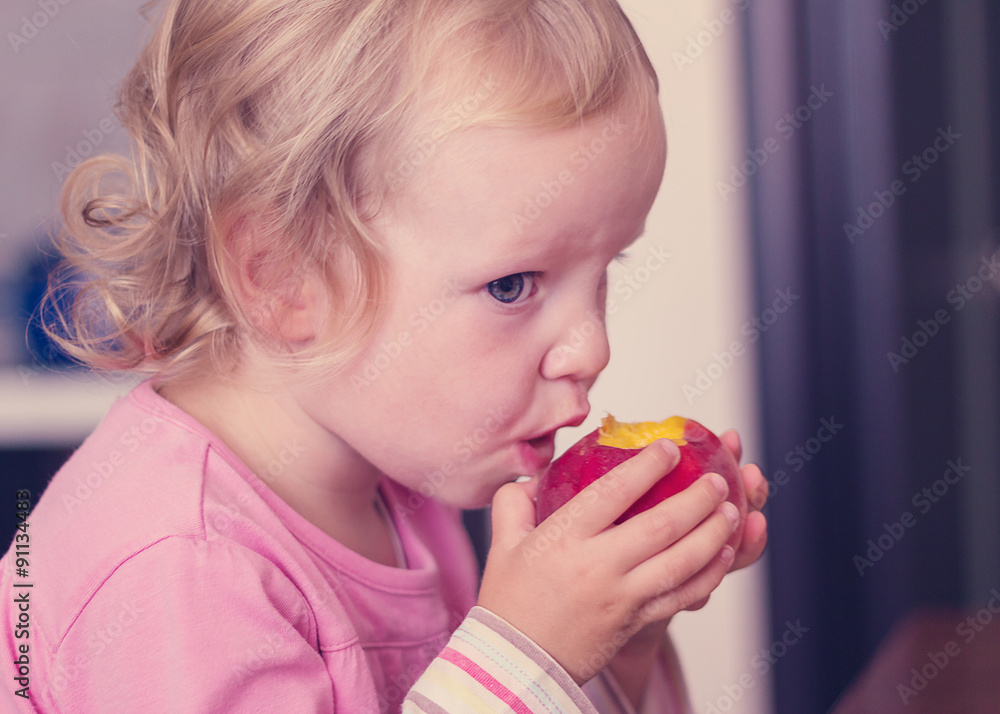 Funny little girl (2 years) eat a peach. Funny little girl (2 years) eat a peach.