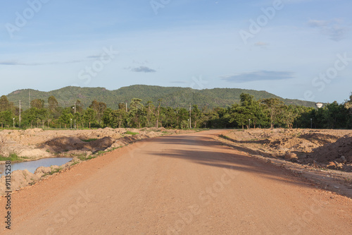 Dry countryside soil road in sunny day