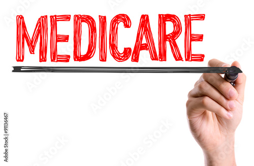 Hand with marker writing the word Medicare photo