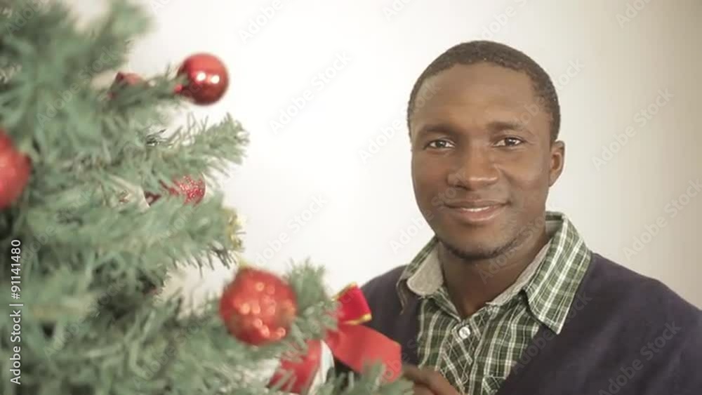 Black man decorating christmas tree Black man decorating christmas tree