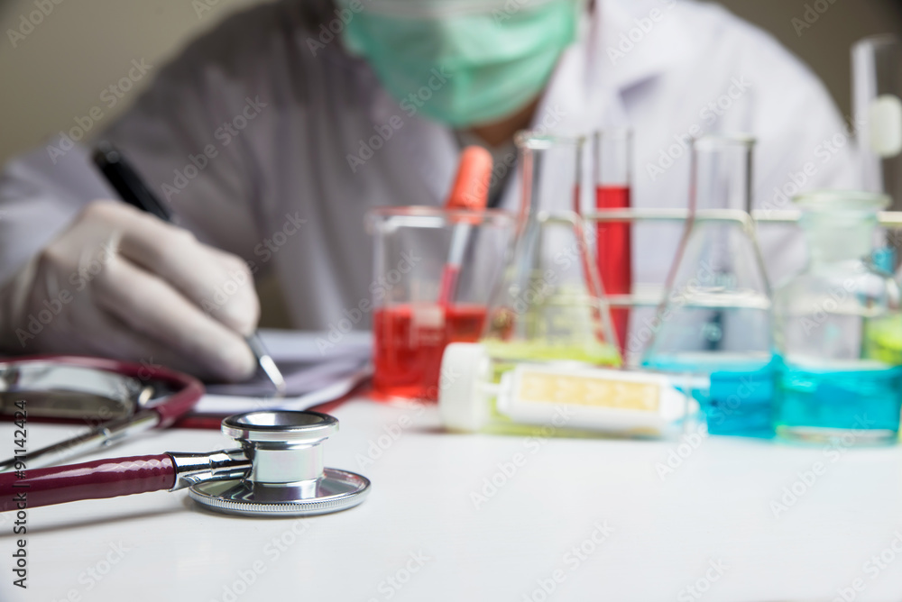 Laboratory glassware with out of focus scientist background Laboratory glassware with out of focus scientist background