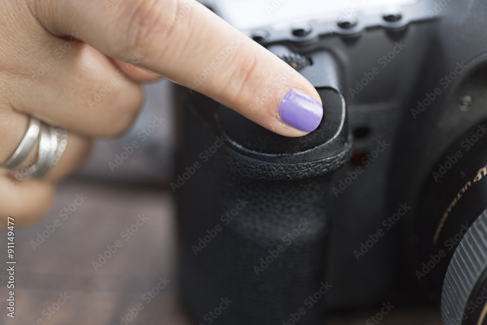 a female finger pushing the release button of a professional digital