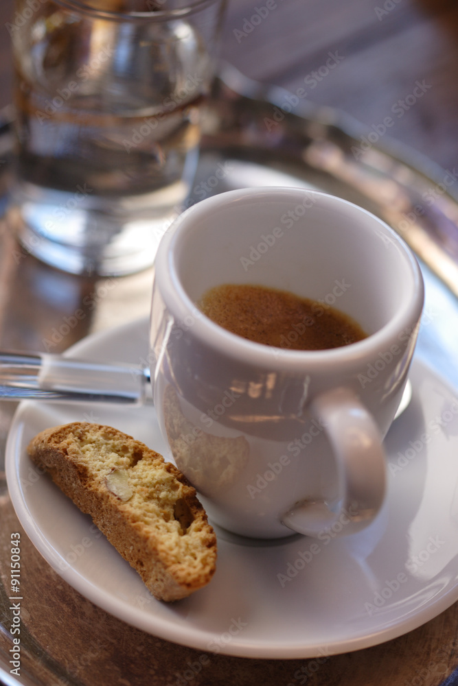 A cup of espresso with cantuccini and a glass of water A cup of espresso with cantuccini and a glass of water