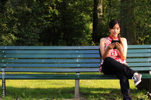 A young Asain woman reading an e-book