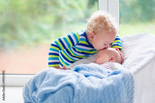 Fotografia Little boy kissing newborn baby brother