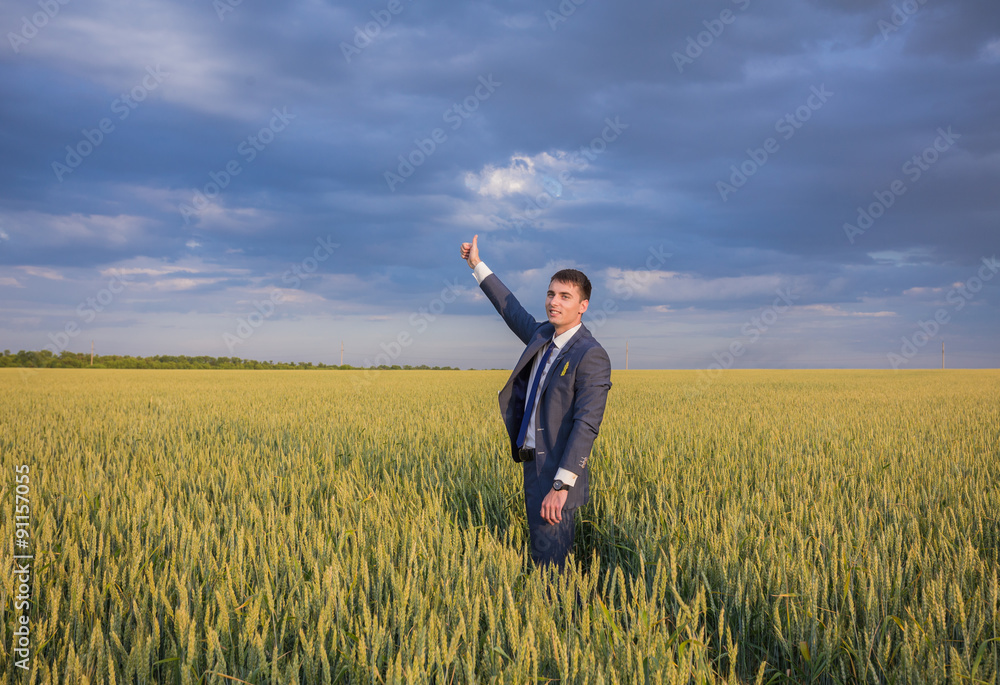 happy farmer, businessman, standing in wheat field with his happy farmer, businessman, standing in wheat field with his