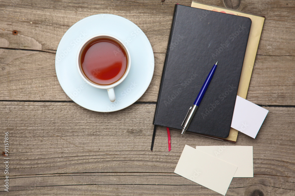 Blank business cards with pen, notebook and tea cup on wooden Blank business cards with pen, notebook and tea cup on wooden